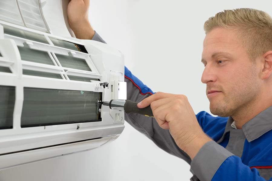 Portrait Of Young Male Technician Repairing Air Conditioner in Mount Vernon, TX.