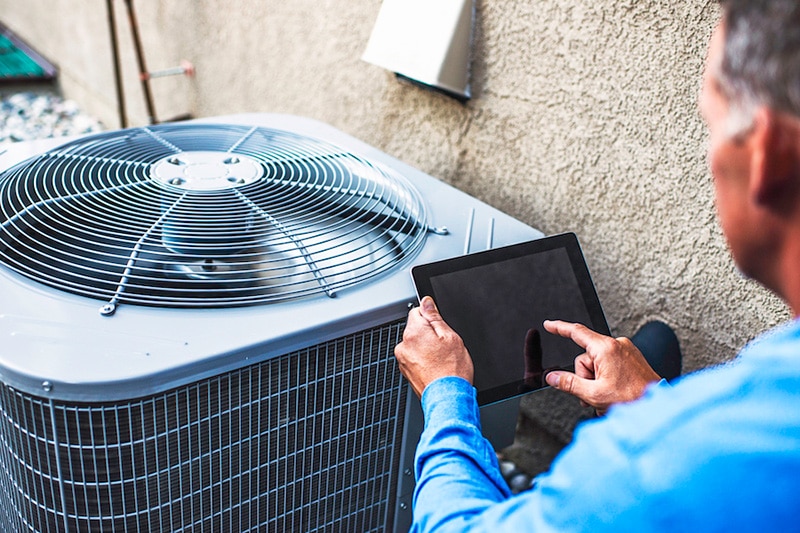 man performing fall maintenance with an AC