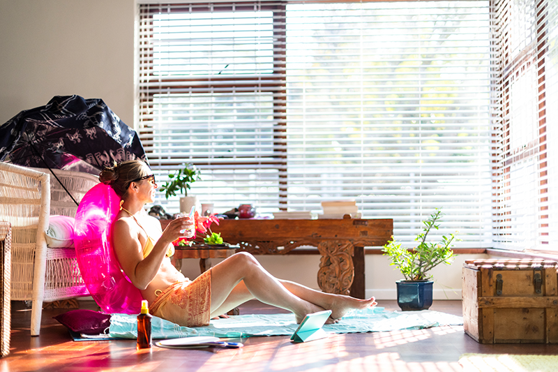 Summer Savings Tips for AC. Woman in living room enjoying the summertime.